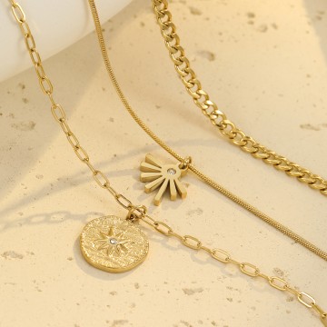 Gros plan sur les pendentifs soleil et demi-lune du collier multirang Soléa en maille serpent et forçat