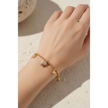 Bracelet coquillages Naïa doré porté au poignet pour un look plage