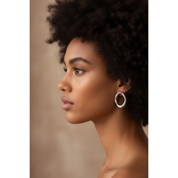 Boucles d'oreilles Romy argentées portées pour un style minimaliste chic